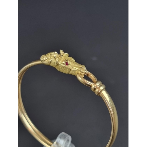 233 - A Gay Frères bangle, decorated stylised horse head with faceted ruby set eyes, having stamped maker'... 