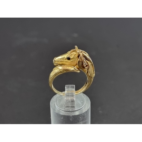 234 - A Garrard & Co 18ct gold stylised horse head ring, set cabochon ruby eye and six diamonds to man... 