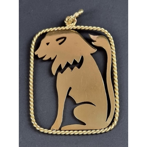 241 - An unusually large yellow metal pendant, decorated a central panel of a seated lion within a twisted... 