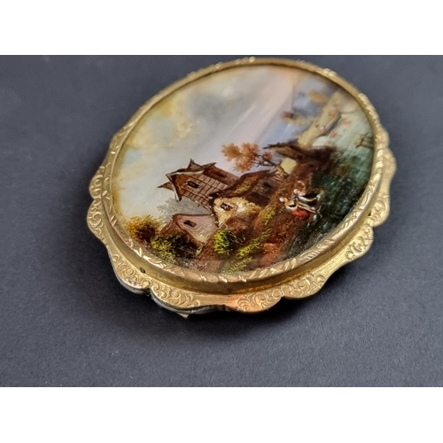 243 - A gold plated brooch, inset mother-of-pearl panel painted with anglers, 6cm wide.