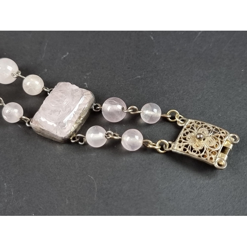 249 - A vintage bracelet, set three carved rose quartz panels, interspersed with sixteen rose quartz beads... 