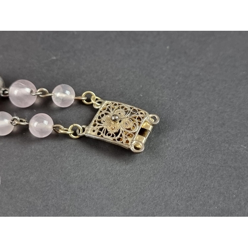 249 - A vintage bracelet, set three carved rose quartz panels, interspersed with sixteen rose quartz beads... 