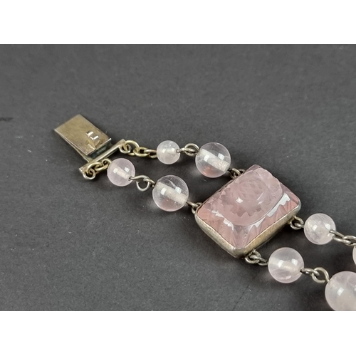 249 - A vintage bracelet, set three carved rose quartz panels, interspersed with sixteen rose quartz beads... 