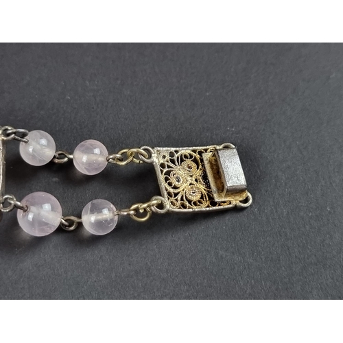 249 - A vintage bracelet, set three carved rose quartz panels, interspersed with sixteen rose quartz beads... 