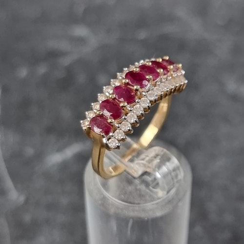 255 - An 18ct gold ruby and diamond ring, set seven faceted rubies with thirteen diamonds to either side, ... 