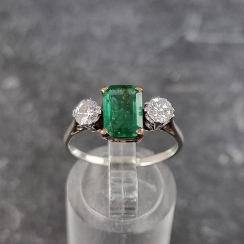 268 - An emerald and diamond three stone ring, set emerald of approximately 1.3ct and two brilliant cut di... 