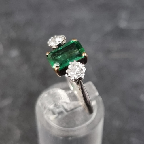 268 - An emerald and diamond three stone ring, set emerald of approximately 1.3ct and two brilliant cut di... 