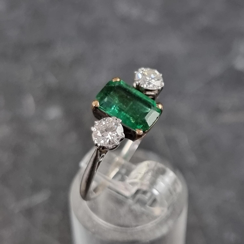 268 - An emerald and diamond three stone ring, set emerald of approximately 1.3ct and two brilliant cut di... 