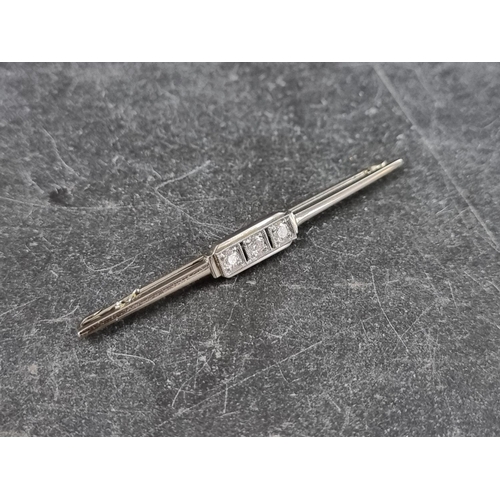 298 - An Art Deco style diamond three stone bar brooch, stamped '18k', 53mm.