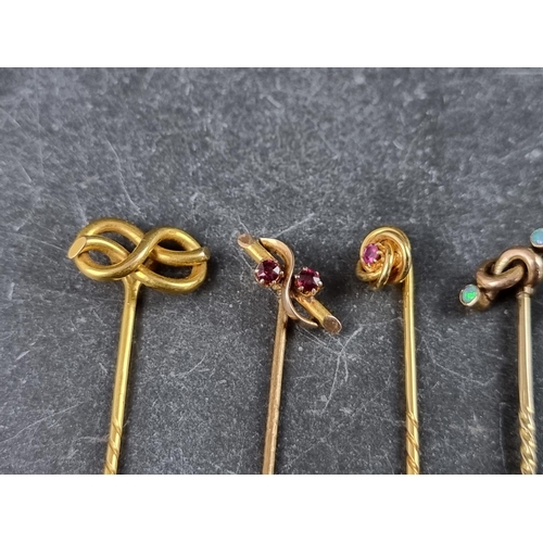 319 - A stick pin, having knot terminal stamped '15ct'; together with four gem set examples. (5)... 