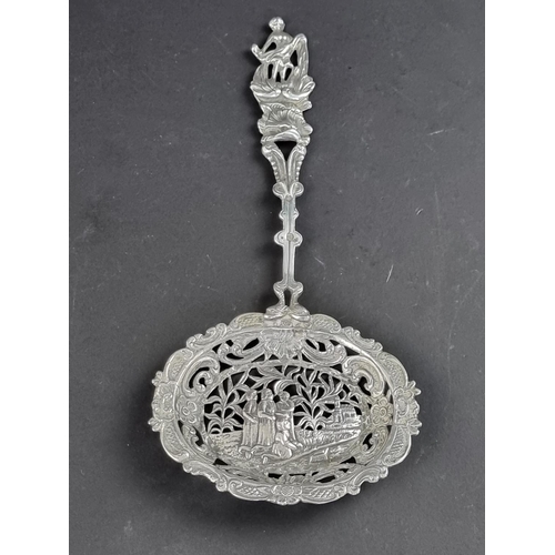 74 - A Continental metal sifter spoon, having figural terminal and decorative bowl.