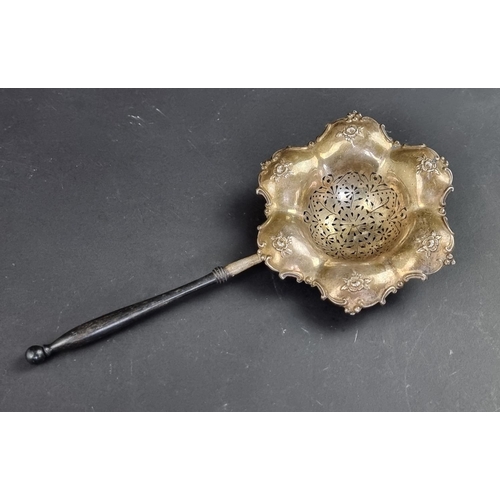 76 - An Edwardian silver strainer, by Gorham Manufacturing Co, Birmingham 1904, with turned wood handle, ... 