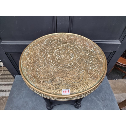 1013 - A brass and ebonized circular table, the top decorated with Chinese motifs, 46cm diameter.... 