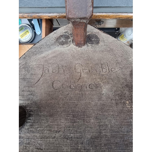 1064 - A carved oak spinning stool, by Jack Grimble, Cromer.