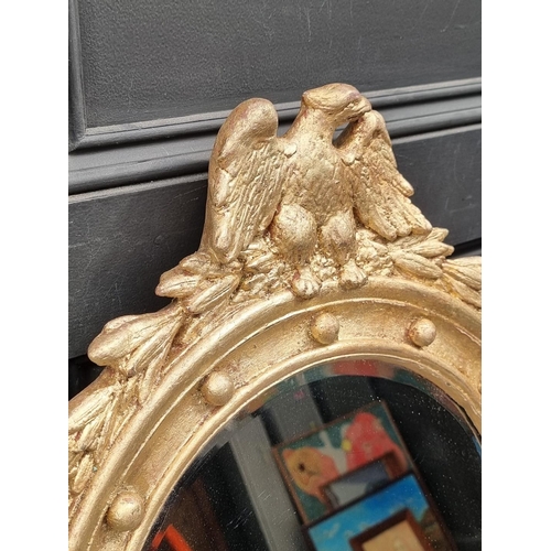 1105 - A 19th century style gilt framed wall mirror, with eagle surmount, 57 x 44.5cm; together with a... 