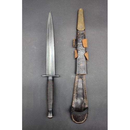 1675 - A Fairbairn Sykes pattern commando fighting knife, 29.3cm long, in brass mounted leather sheath.... 