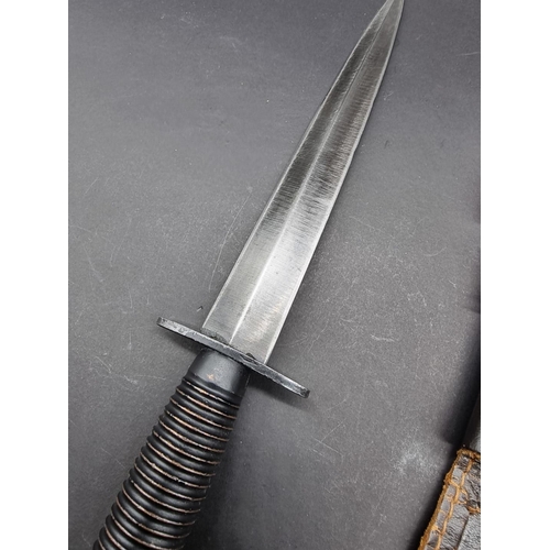 1675 - A Fairbairn Sykes pattern commando fighting knife, 29.3cm long, in brass mounted leather sheath.... 