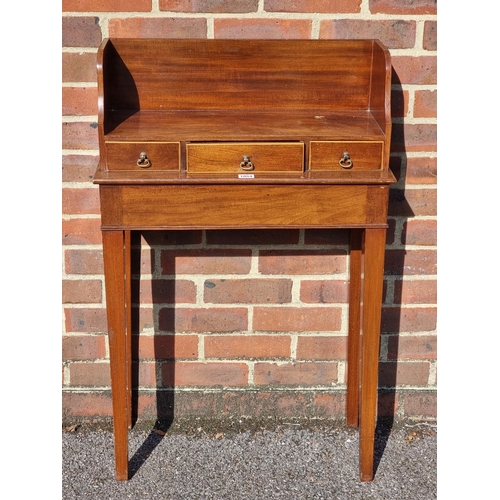 1054 - A small mahogany side table, incorporating three frieze drawers, 61cm wide.