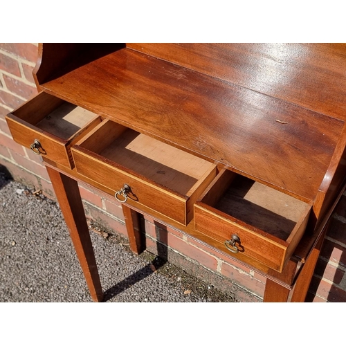 1054 - A small mahogany side table, incorporating three frieze drawers, 61cm wide.