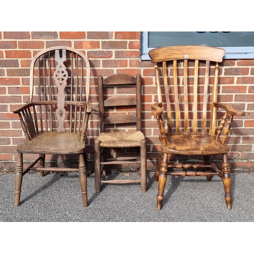 1065 - An antique beech lath back kitchen elbow chair; together with another ash, elm and beech wheelback W... 