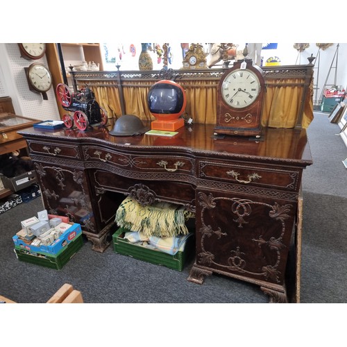 1075 - A large and impressive early 20th century carved mahogany sideboard, with original brass gallery bac... 