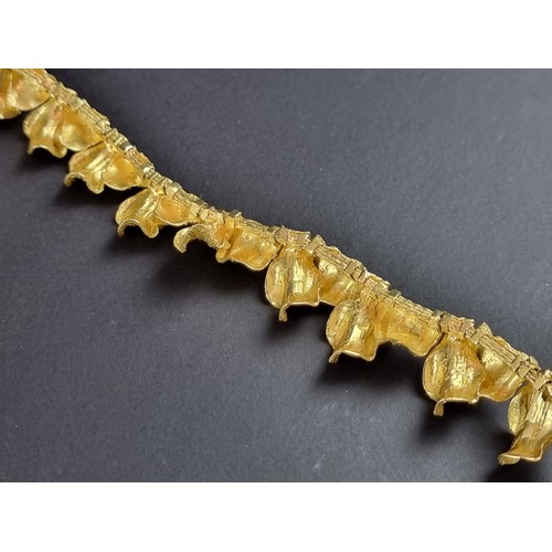 239 - A chunky yellow metal necklace, designed as a single row of overlapping leaves, stamped 'T 0750 AM39... 