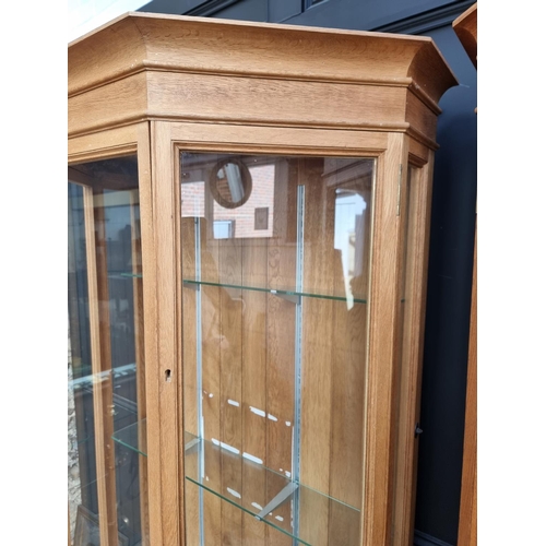 1002 - A large pair of modern pale oak display cabinets, 242cm high x 96cm wide x 48cm deep.... 