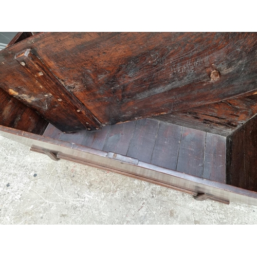 1038 - An early 19th century elm dough bin and cover, 114cm wide.