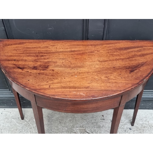 1039 - A George III mahogany and line inlaid demi-lune tea table, with double gateleg action, 95.5cm wide.... 