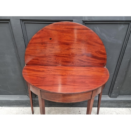 1039 - A George III mahogany and line inlaid demi-lune tea table, with double gateleg action, 95.5cm wide.... 