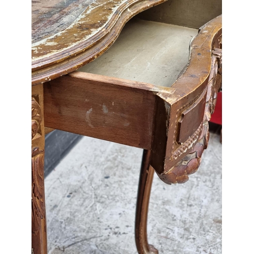 1050 - A Louis XV style giltwood writing table, 77cm wide, (lacking inset surface).