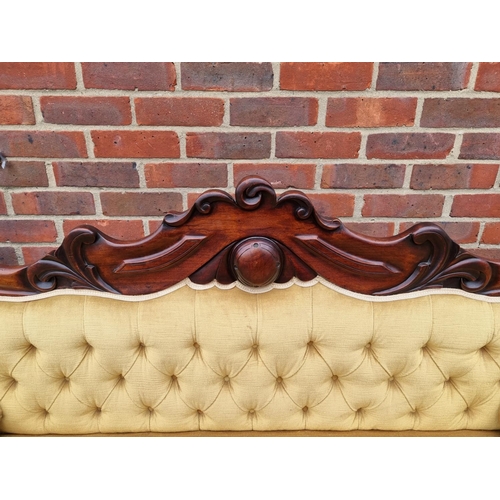 1074 - An early Victorian carved mahogany and button upholstered scroll arm settee, 201cm wide.... 