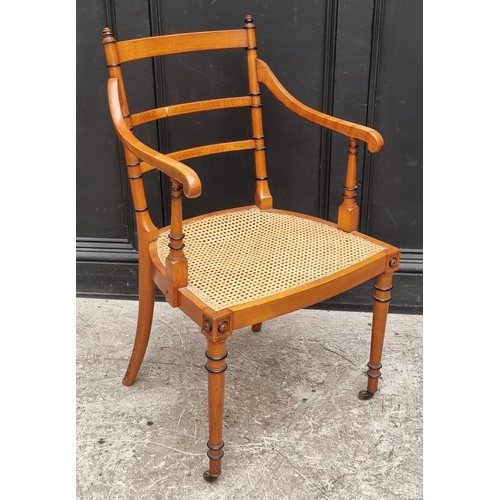 1076 - An unusual late Victorian fruitwood and cane seated open arm elbow chair, by 'Howard & Sons Ltd,... 