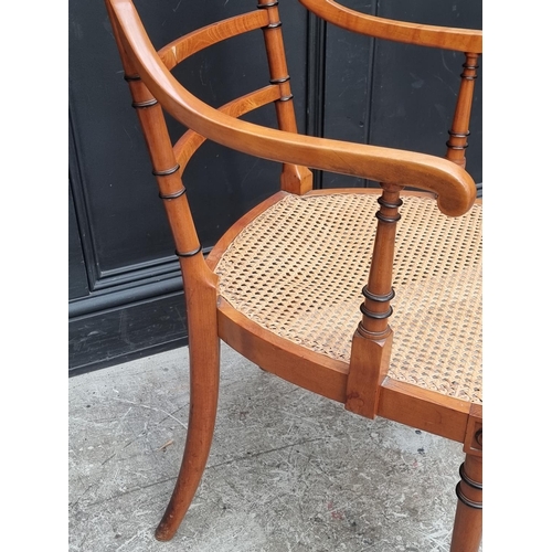 1076 - An unusual late Victorian fruitwood and cane seated open arm elbow chair, by 'Howard & Sons Ltd,... 