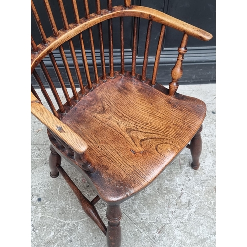 1077 - A 19th century ash and elm Windsor armchair, (legs reduced).