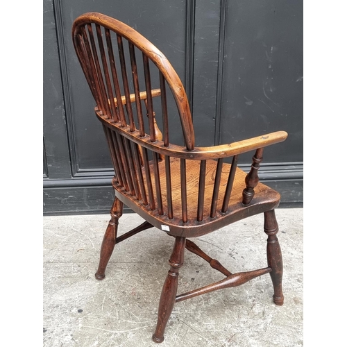 1077 - A 19th century ash and elm Windsor armchair, (legs reduced).