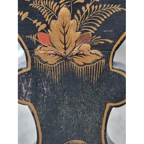 1085 - A 1920s black and gilt chinoiserie open arm low elbow chair.