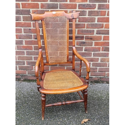 1080 - A 19th century fruitwood and cane open arm elbow chair. 