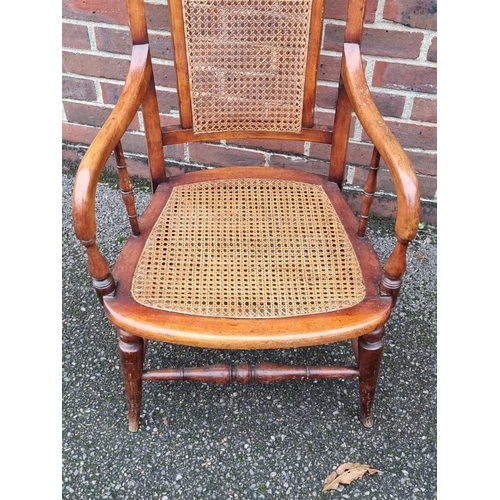 1080 - A 19th century fruitwood and cane open arm elbow chair. 