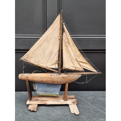 1526 - A small old pine pond yacht, the hull 48cm long, on conforming stand, total height 71cm.... 