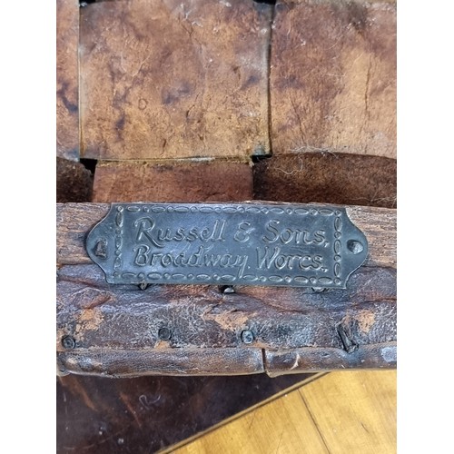 1033 - An early Gordon Russell oak and tan leather stool, labelled, 35.5cm wide.