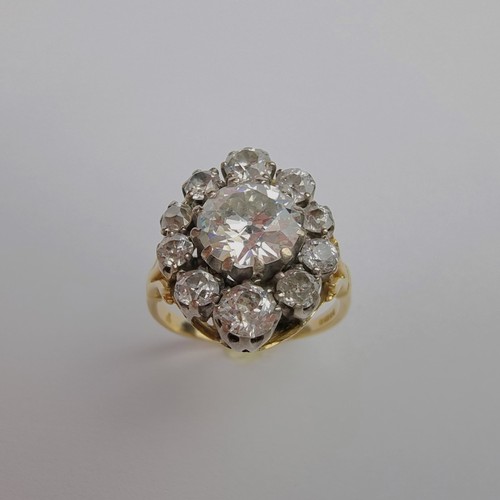 An impressive 18ct gold diamond cluster ring, the central brilliant cut diamond of approximately 1.8ct surrounded by ten graduated mixed diamonds, estimated at a further 1.2ct in total, London 1987, size T, gross weight 7.5g.