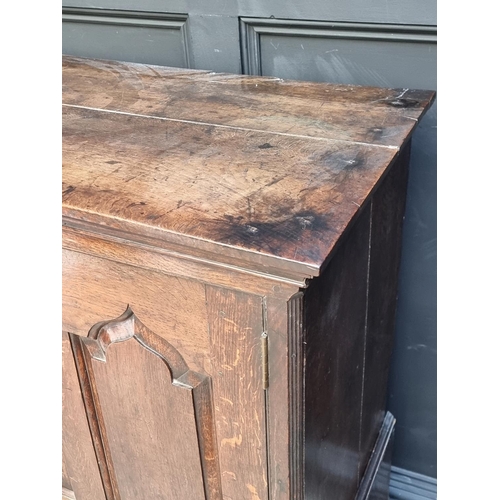 1045 - An 18th century oak panelled side cabinet, 135.5cm wide, (converted from a mule chest).... 