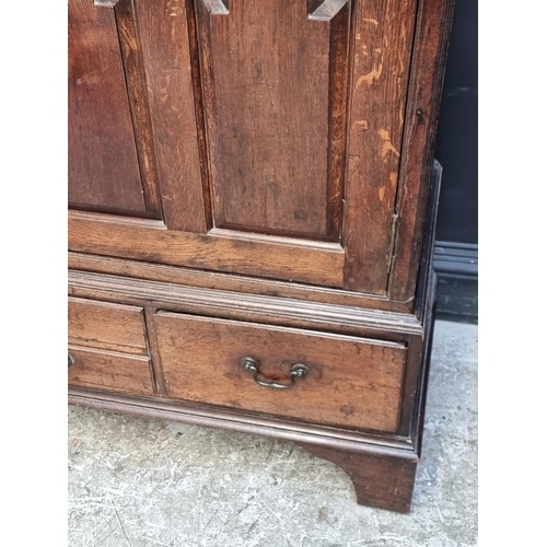 1045 - An 18th century oak panelled side cabinet, 135.5cm wide, (converted from a mule chest).... 