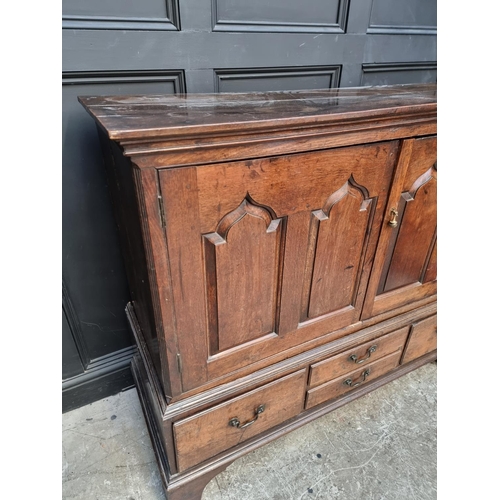 1045 - An 18th century oak panelled side cabinet, 135.5cm wide, (converted from a mule chest).... 