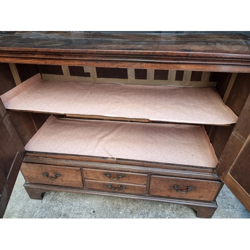 1045 - An 18th century oak panelled side cabinet, 135.5cm wide, (converted from a mule chest).... 