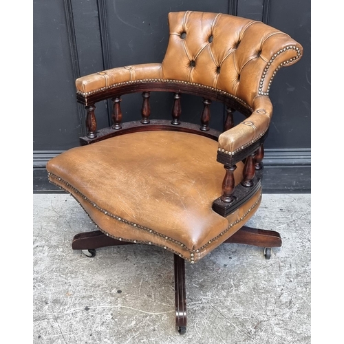 1064 - A buttoned leather revolving desk chair.