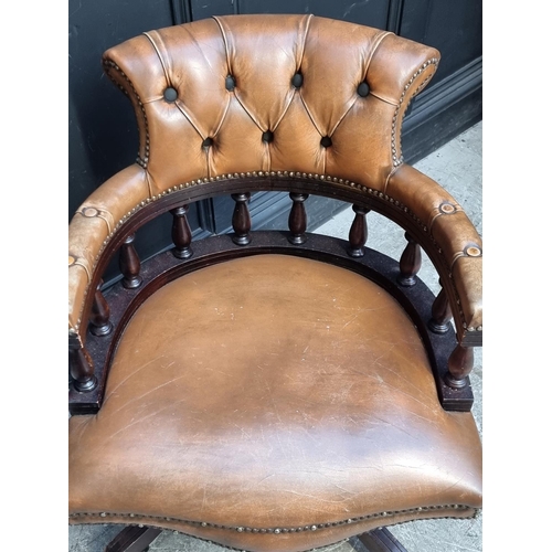 1064 - A buttoned leather revolving desk chair.