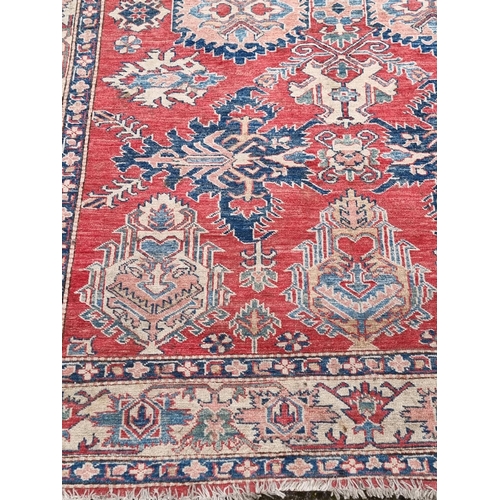 1103 - A Tribal design rug, having geometric and floral borders, 218 x 175cm.