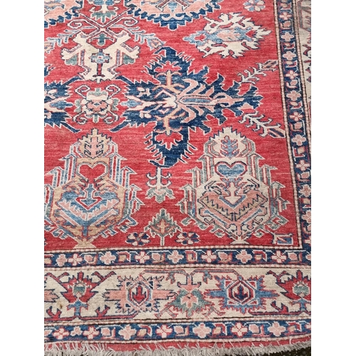 1103 - A Tribal design rug, having geometric and floral borders, 218 x 175cm.